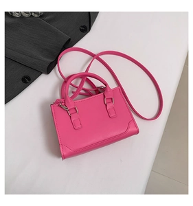 Vue détaillée du mini sac carré magenta avec garnitures argentées et bandoulière