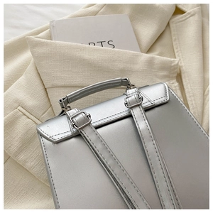 Detail of silver metallic backpack back showing adjustable straps and top handle