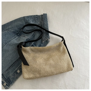Gros plan détaillé montrant la texture tissée serrée et la sangle noire du sac cabas