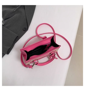Vue de dessus du sac à bandoulière en cuir rose et paille avec détails du compartiment