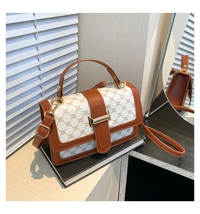 Détail du sac bandoulière vintage montrant les bords en cuir et le fermoir métallique