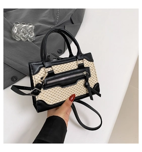 Détail d'un sac bandoulière vintage en paille et cuir noir avec gland et poignée