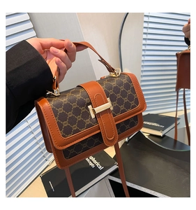 Détail du sac à bandoulière vintage avec bordure en cuir marron et fermoir en métal doré