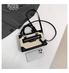 Vue détaillée de la texture tissée et des contrastes en similicuir noir du sac à main