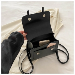 Interior view of black PU leather crossbody bag showing main compartment and front pocket