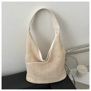 Détail du sac cabas tressé crème avec bandoulière en cuir et texture évidée