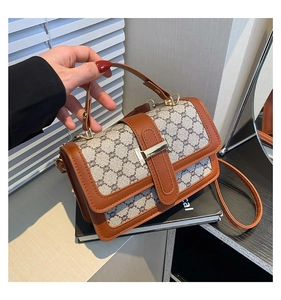 Détail d'un sac à main vintage en cuir marron avec boucle métallique sur fond blanc
