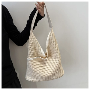 Détail du sac à bandoulière tissé crème au design minimaliste à larges mailles ajourées