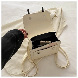 Detail of cream leather shoulder bag interior showing main compartment and front pocket