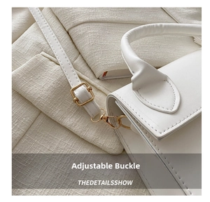 Detailed macro of white leather bag featuring golden adjustable buckles and fine stitching