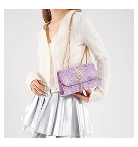 Détail du sac bandoulière lilas en cuir gaufré avec boucle S dorée et pompon