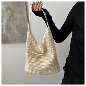 Détail du sac cabas tressé crème montrant la texture et la structure en maille