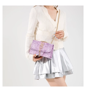 Détail du sac à bandoulière lilas effet croco avec logo S doré et pampilles élégantes