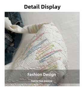 Detailed macro view of white canvas bag with embossed patterns and pastel embroidery