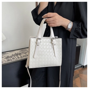 Detail of white woven square handbag with silver hardware and fashion bags logo