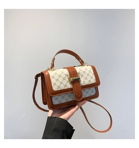 Gros plan d'un sac à main vintage en toile monogramme beige avec bordure en cuir marron