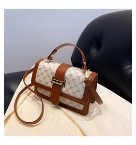 Détail du sac bandoulière vintage avec motif monogramme et boucle en métal doré