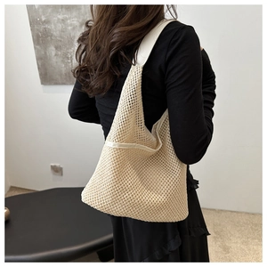 Détail du sac seau tissé crème avec bordures en cuir pour tenue d'été décontractée