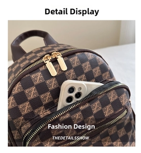 Macro view of checkered travel backpack with front pocket holding a smartphone