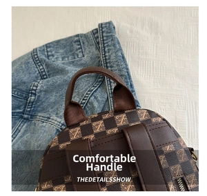 Detail of comfortable carry handle on check pattern backpack with metal zipper