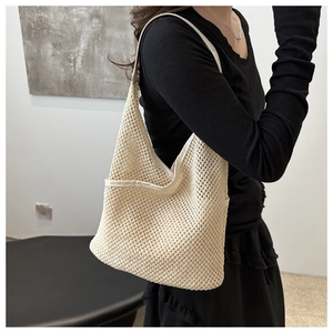 Détail du sac cabas en maille tressée crème montrant la texture et la bandoulière large