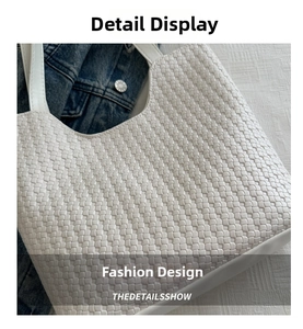 Detailed view of white woven fabric tote bag with premium leather handle texture