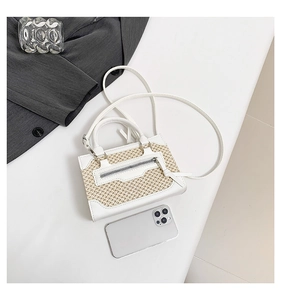 Vue détaillée de dessus du mini sac bandoulière en paille avec finitions en cuir blanc