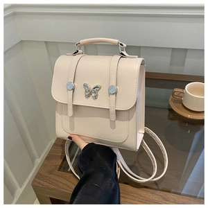 Detail of soft pink square backpack with a silver butterfly clasp and leather straps
