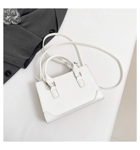 Vue de dessus d'un sac à main blanc minimaliste en cuir avec anneaux argentés