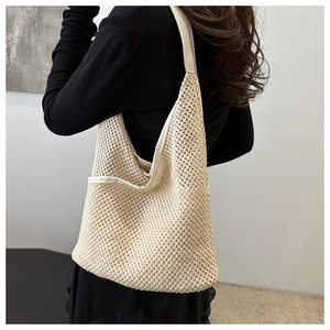 Gros plan sur la texture du sac seau en maille tressée beige avec détails en coton