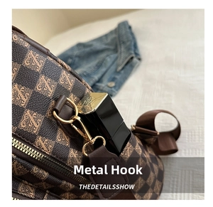 Close-up of checkered brown backpack detail with gold-tone hardware and side hook