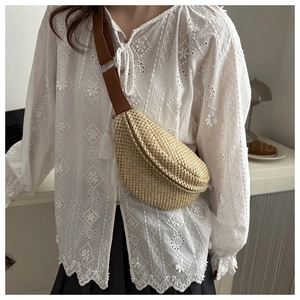 Détail du mini sac de poitrine en paille tissée avec sangle brune et boucle en métal