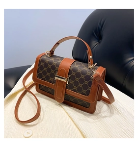 Détail d'un sac à main vintage en toile marron avec texture géométrique et boucle dorée