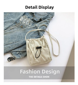 Close-up of cream nylon crossbody bag with pleated texture and black drawstring toggle