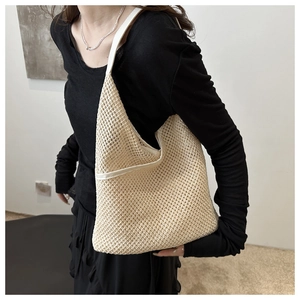 Détail du tissage en maille beige avec bandoulière en cuir blanc et finitions de couture