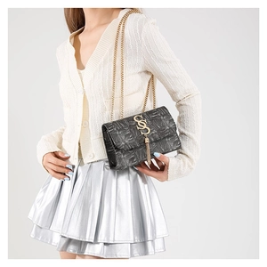 Sac bandoulière noir motif crocodile avec boucle S dorée et glands métalliques