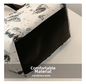 Detailaufnahme des Stoffes mit Schmetterlingsdruck und schwarzem Taschenboden