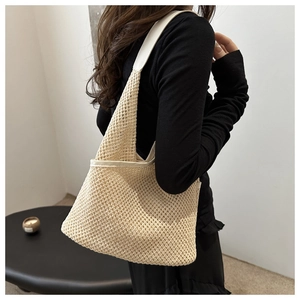 Détail du sac à bandoulière en maille tissée avec bordure en similicuir crème et texture