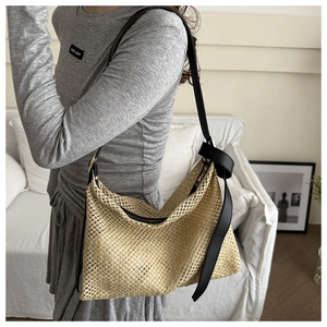 Détail de sac cabas tissé main avec lanières en cuir noir et fermeture éclair
