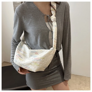 Sac à main blanc en toile matelassée avec broderies colorées et motif texturé élégant