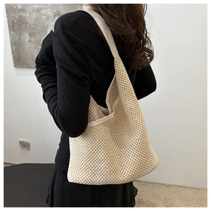 Mannequin portant un grand sac fourre-tout en paille tressée beige au style décontracté