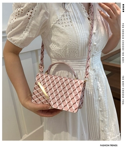 Close-up of pink geometric plaid pattern and metal lock on luxury leather crossbody bag