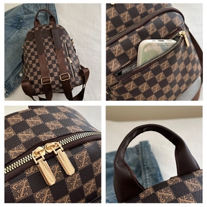 Detail view of mini checkered backpack showing golden zippers and spacious front pocket