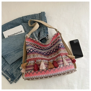 Close-up of bohemian woven tote bag featuring colorful fringe and geometric textures
