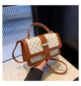 Détail du sac à bandoulière en toile vintage avec garniture en cuir et boucle dorée