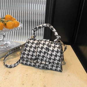 Chic black and white houndstooth pattern crossbody bag with detachable strap and top handle