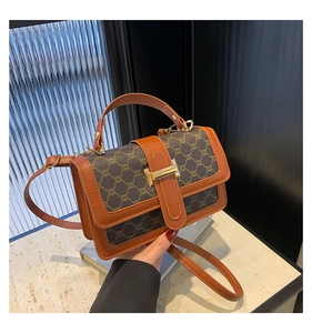 Détail du sac bandoulière vintage avec motif monogramme marron et boucle en H dorée