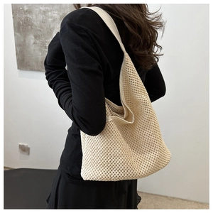 Gros plan du sac hobo en maille tressée beige montrant la texture et la bandoulière