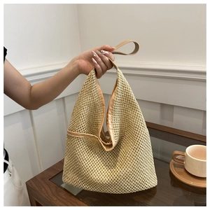 Gros plan sur le sac en paille tisse avec anses en cuir et silhouette triangulaire