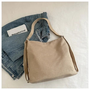 Detail of minimalist beige canvas tote bag with wide strap and side support structure